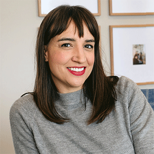 Headshot of Lindsay Neibauer, wearing a gray top and red lipstick.